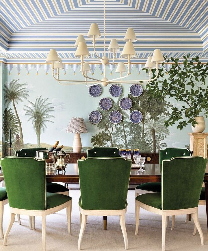 Eclectic dining room with tropical palm tree mural, striped ceiling, and wall-mounted blue plates