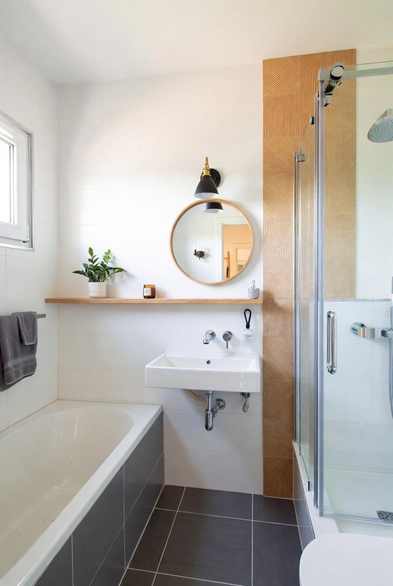 Bathroom wall decor featuring vertical wood pattern tile strip next to glass shower