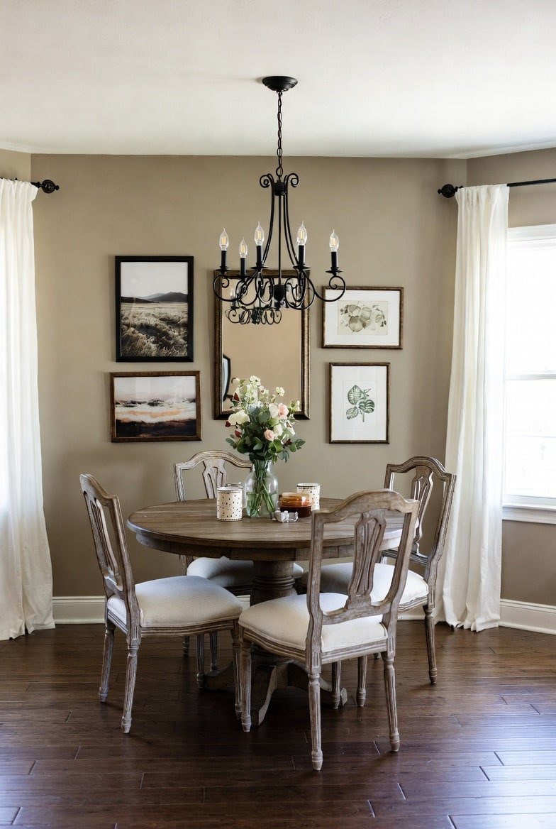 Beige dining nook featuring a gallery wall with a central mirror and framed nature prints