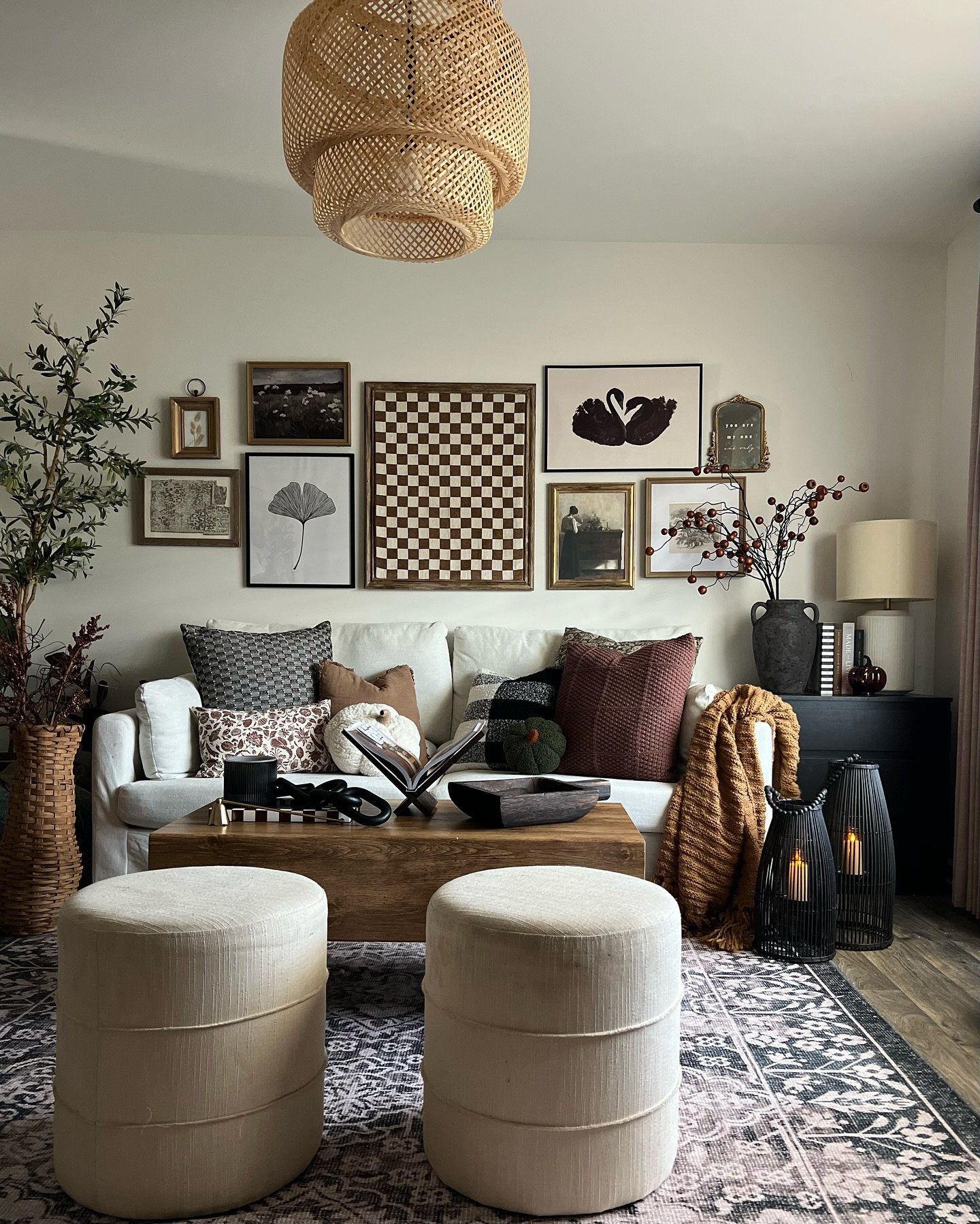 Mixed gallery wall with checkerboard art and vintage frames above white sofa.