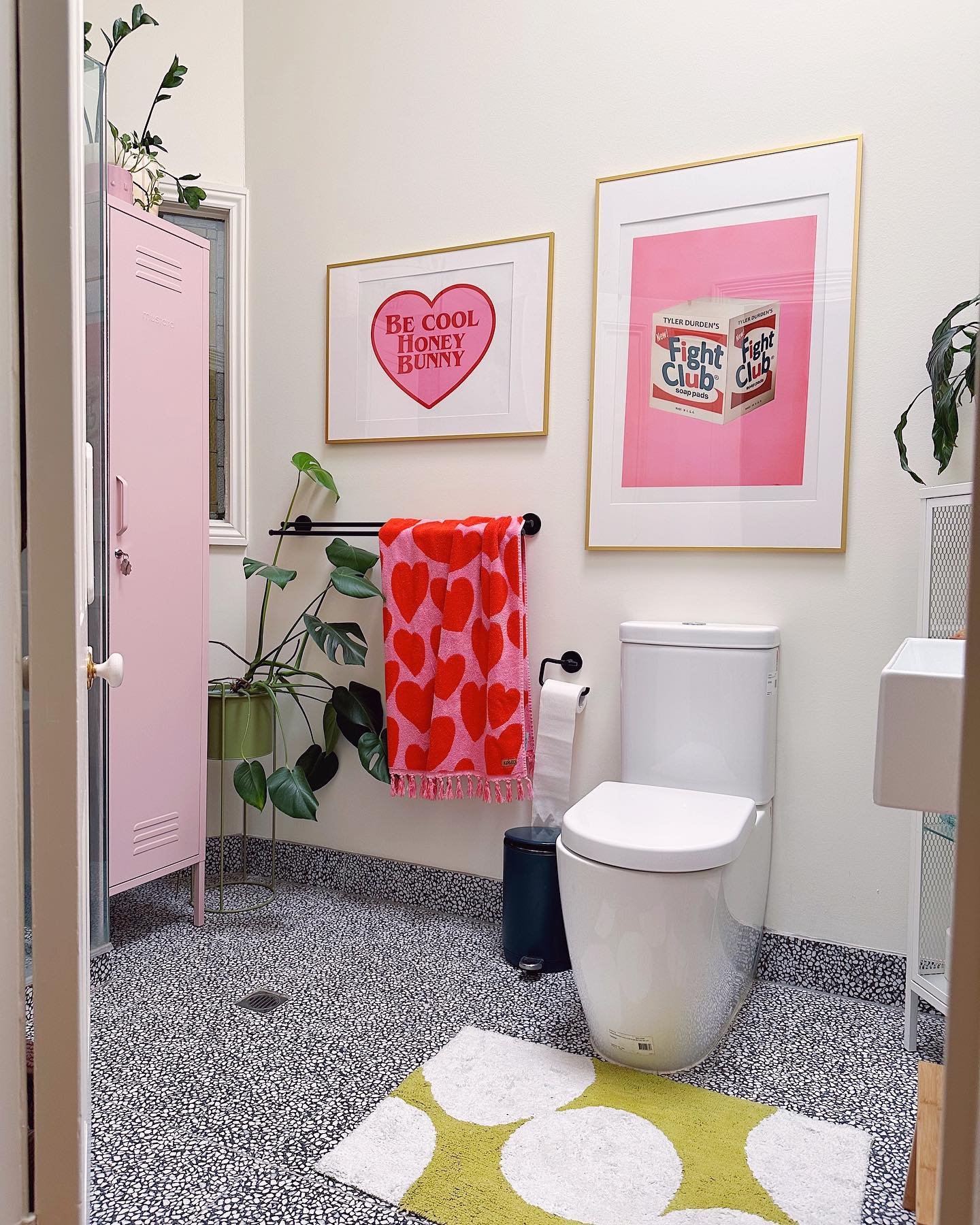 Bathroom white wall decor with pink heart art prints and metal locker
