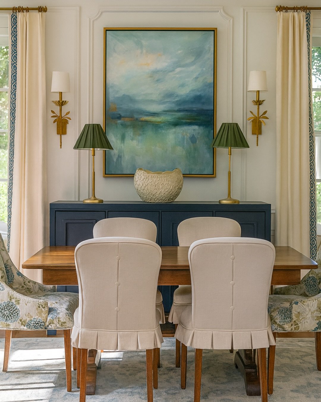 Traditional dining room wall with blue landscape art and gold sconces