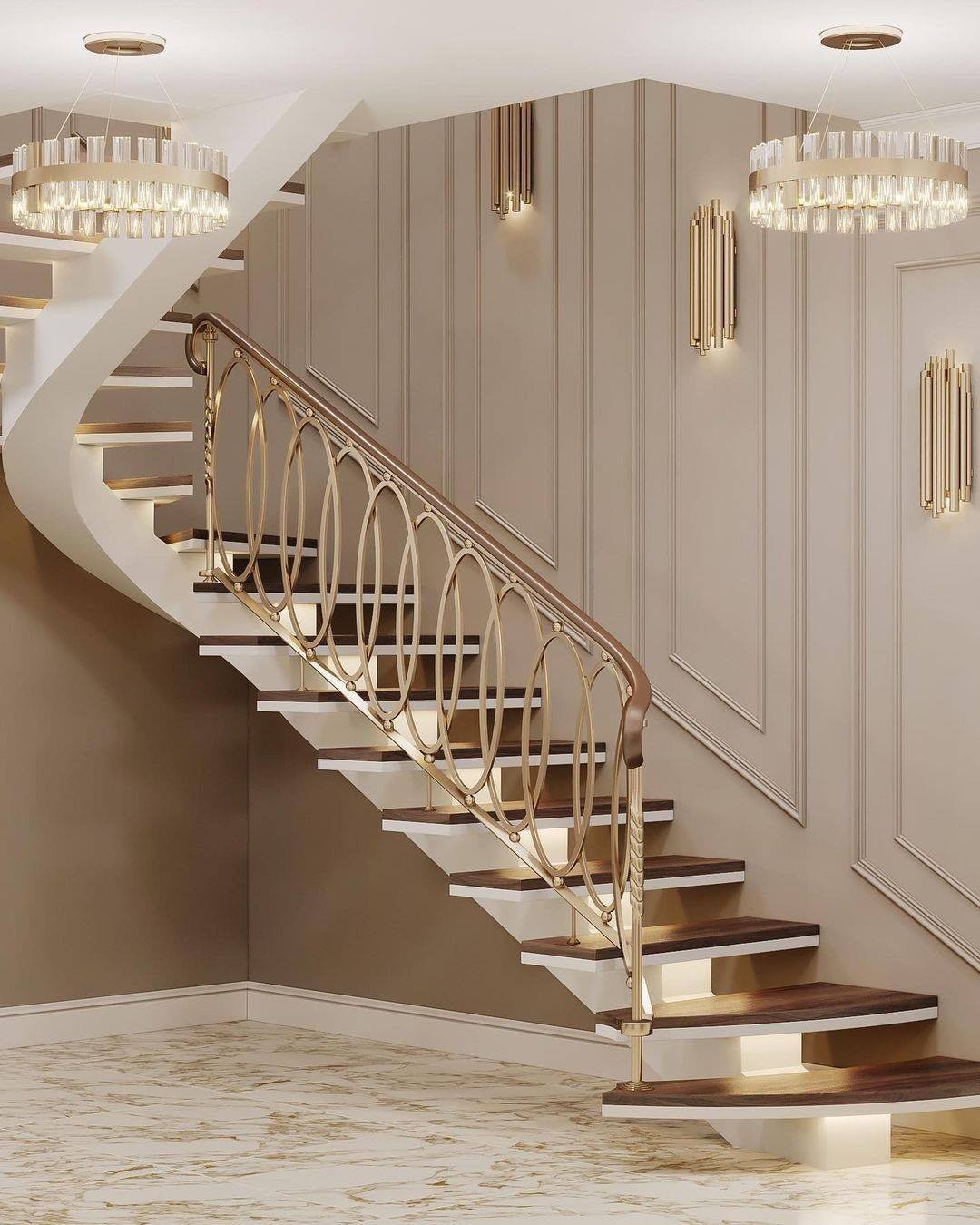 Beige staircase wall featuring picture frame molding and modern gold tube sconces behind a curved railing.