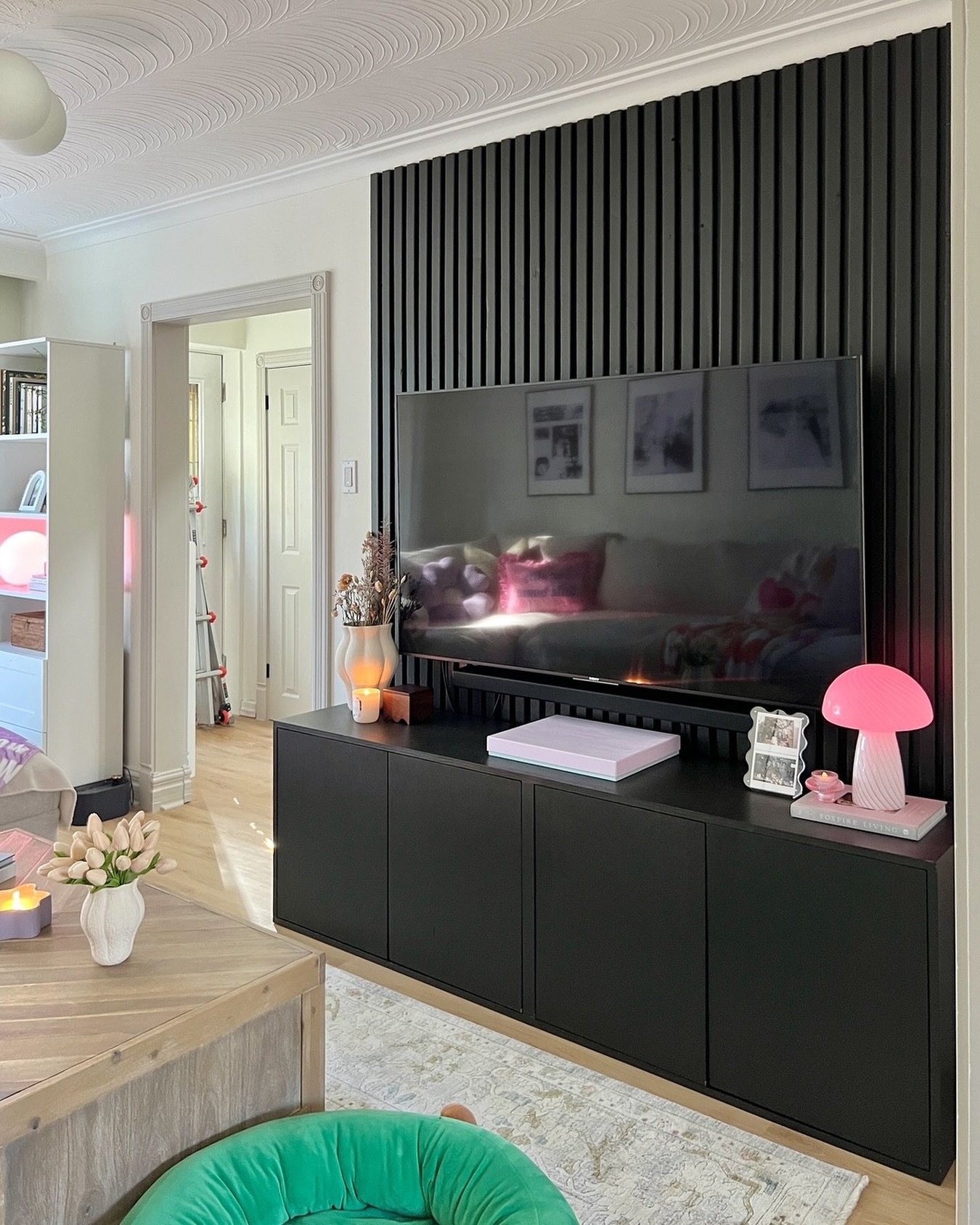 Black vertical wood slat accent wall with dark media console.