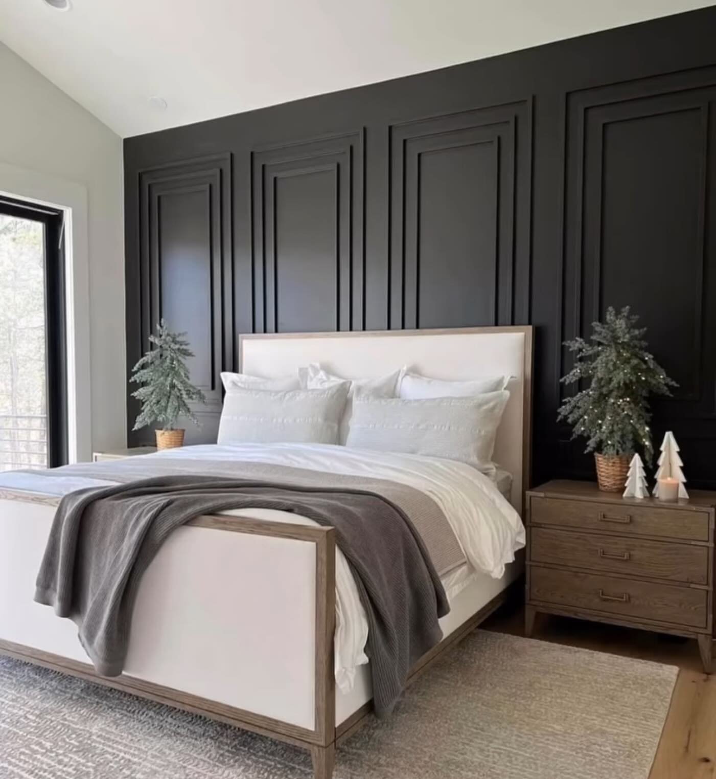 Bedroom featuring a floor-to-ceiling vertical wood slat accent wall with hanging pendant lights and a beige bed.