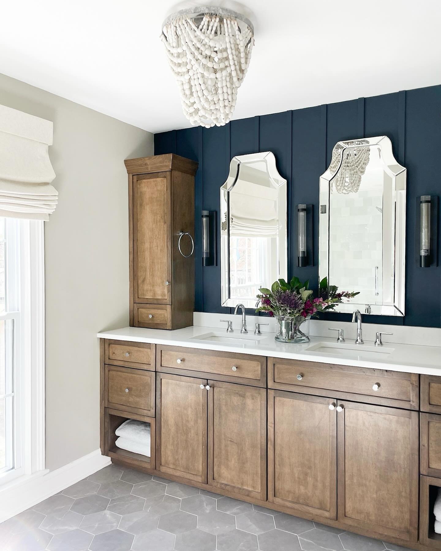 Double bathroom vanity featuring a deep navy blue board and batten accent wall.