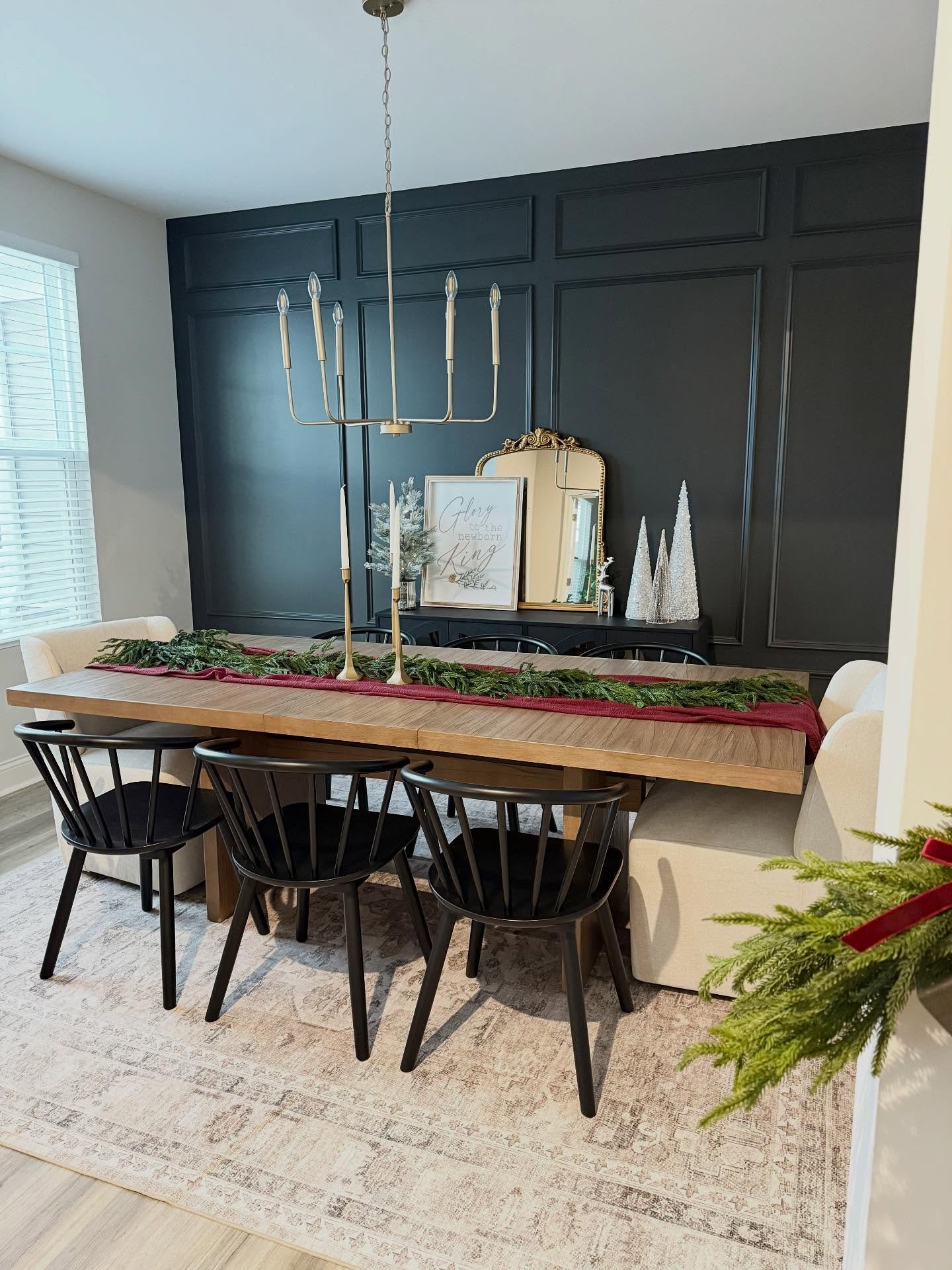 Black dining room accent wall featuring large grid board and batten molding with holiday decor.