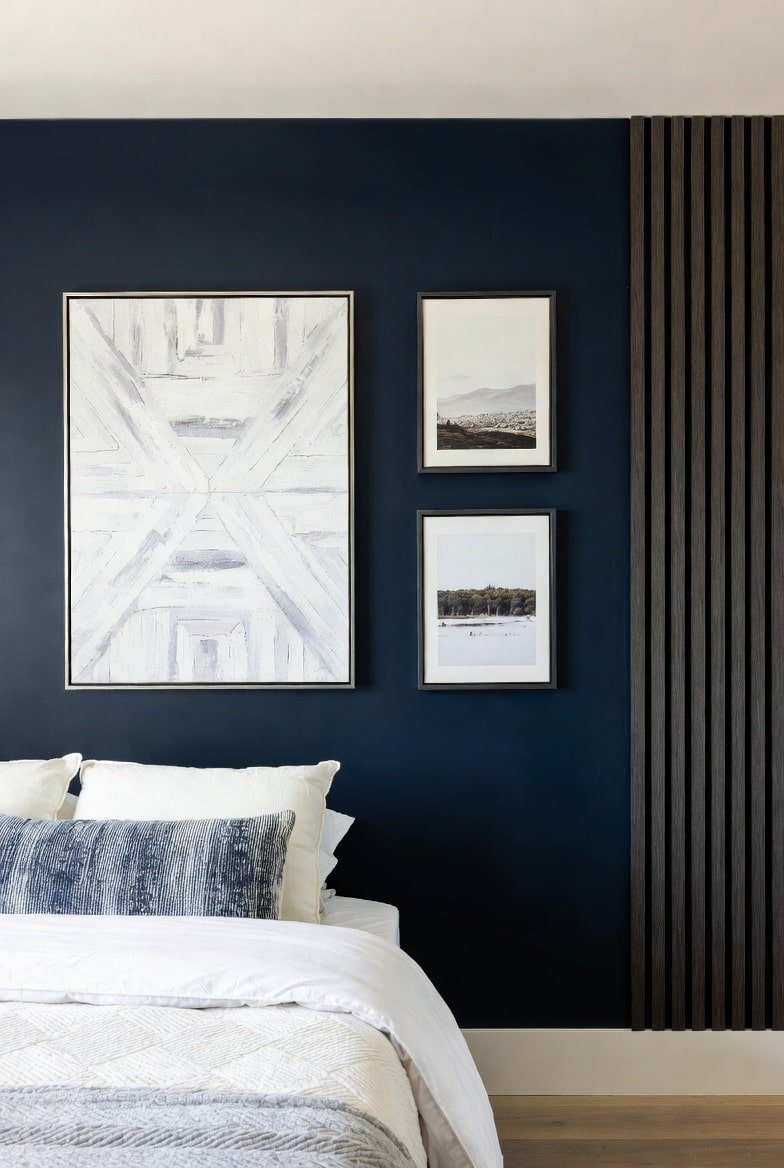 Navy blue accent wall featuring vertical wood slat detailing and framed artwork