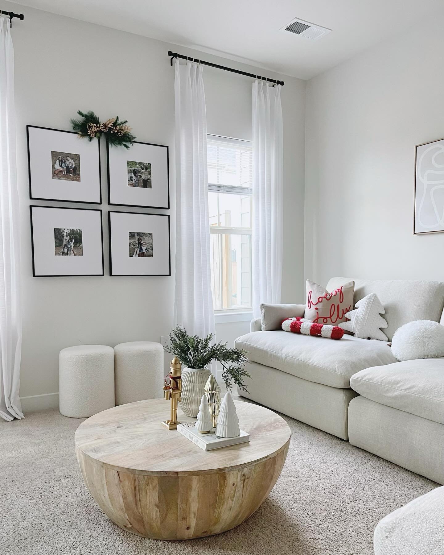 White living room wall featuring a square grid of four black-framed family photos next to a window.
