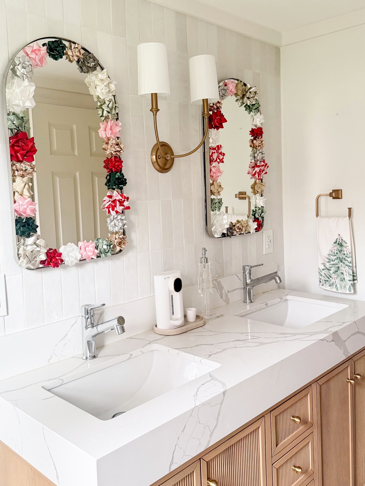 Bathroom wall decor featuring mirrors wrapped in colorful gift bows on vertical white tile