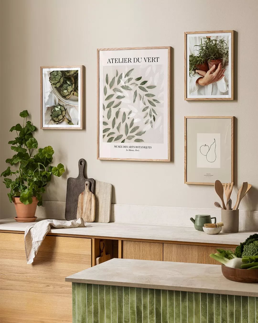 Kitchen wall featuring framed botanical art prints and wooden accessories