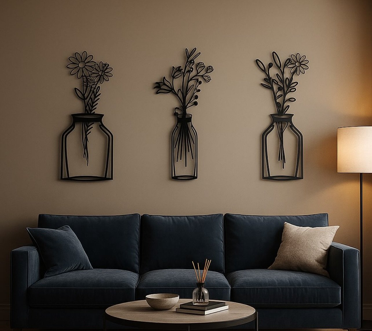 Beige living room wall featuring three black metal wire flower vase sculptures above a dark blue sofa.