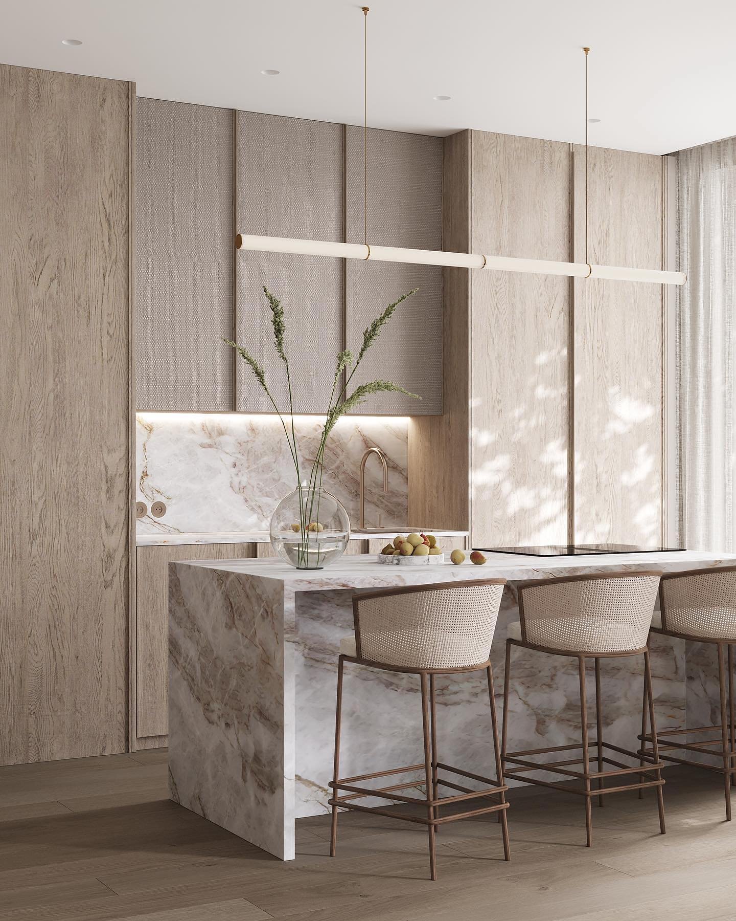 Sleek horizontal tube light hanging above a marble kitchen island with cane stools.