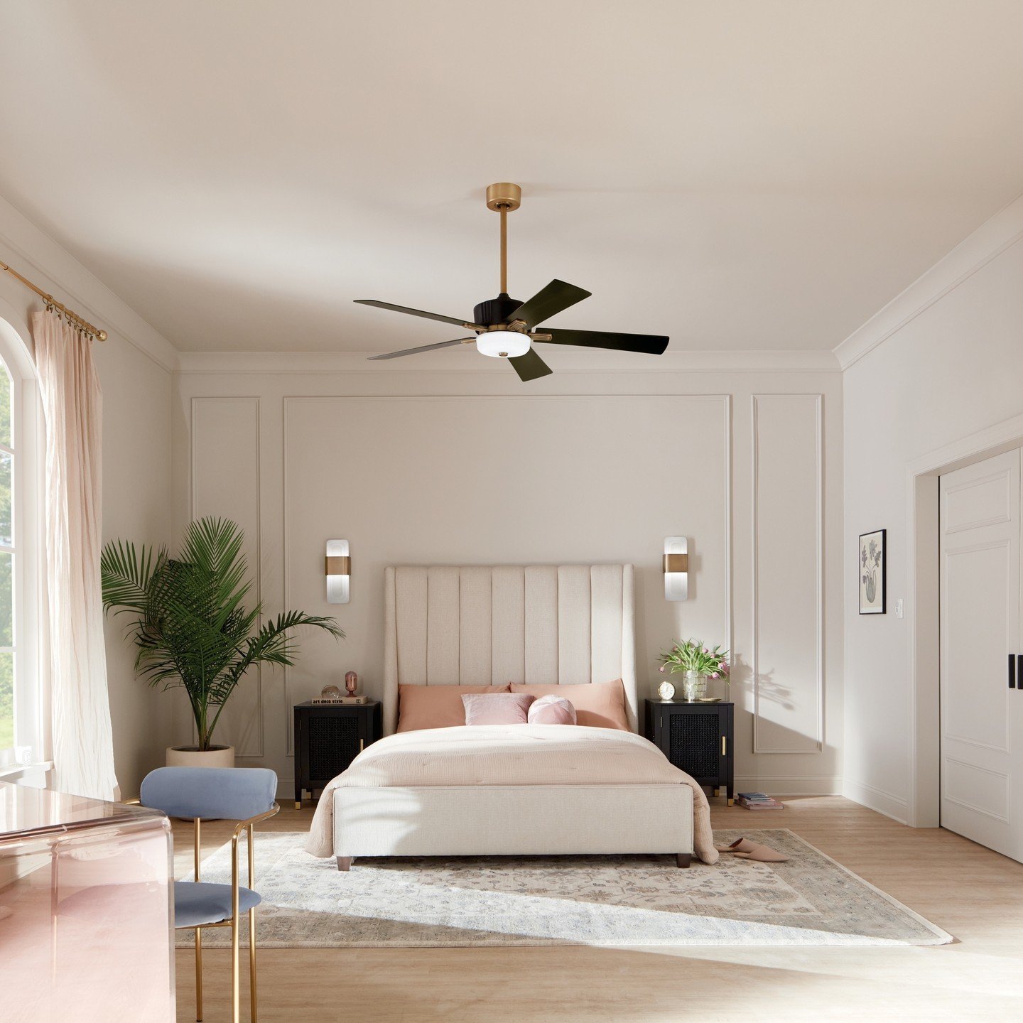 White bedroom with wall molding accent wall featuring gold sconces and a central ceiling fan.