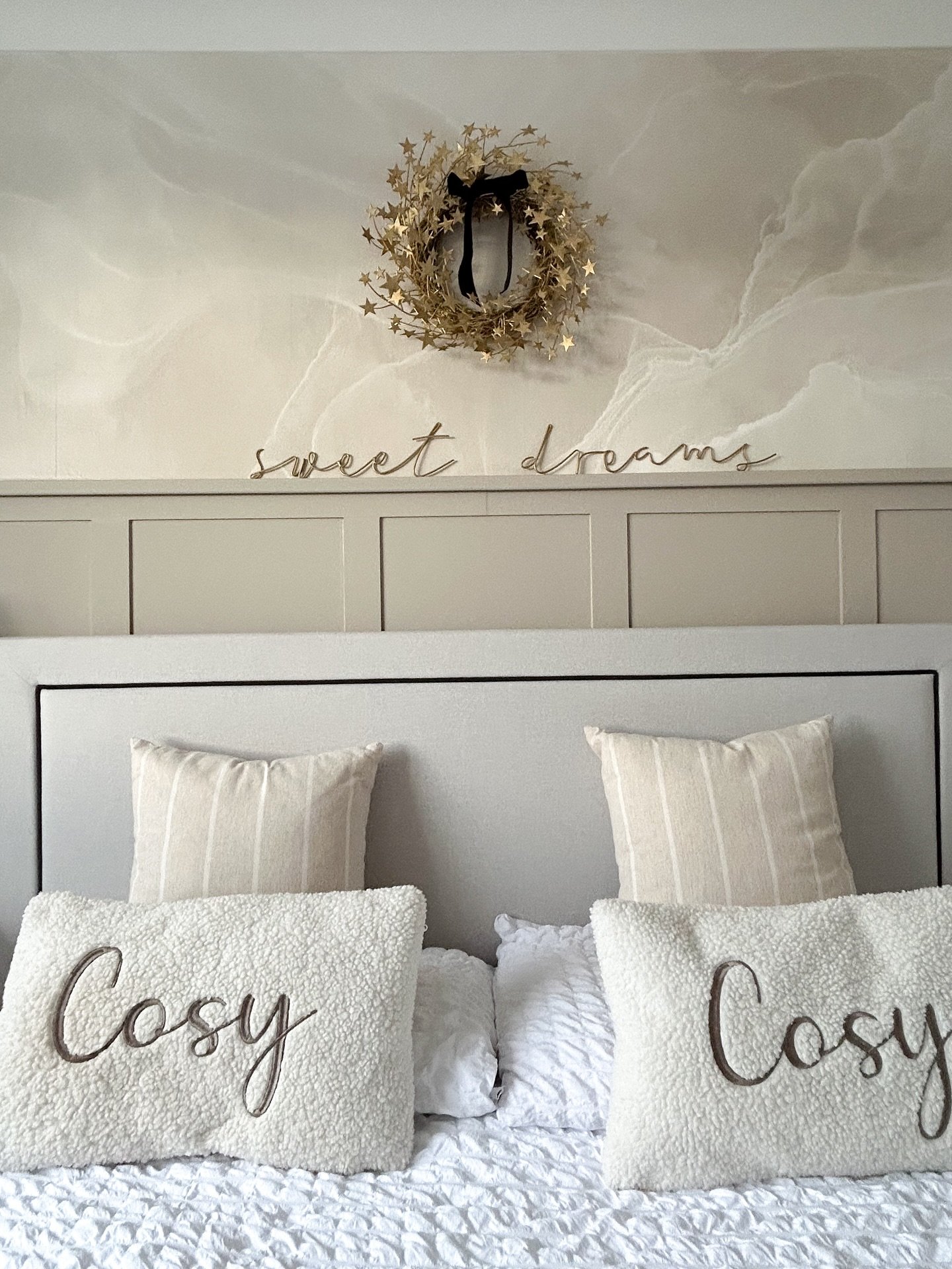 Gold star wreath and sweet dreams sign on beige paneled wall with marble wallpaper