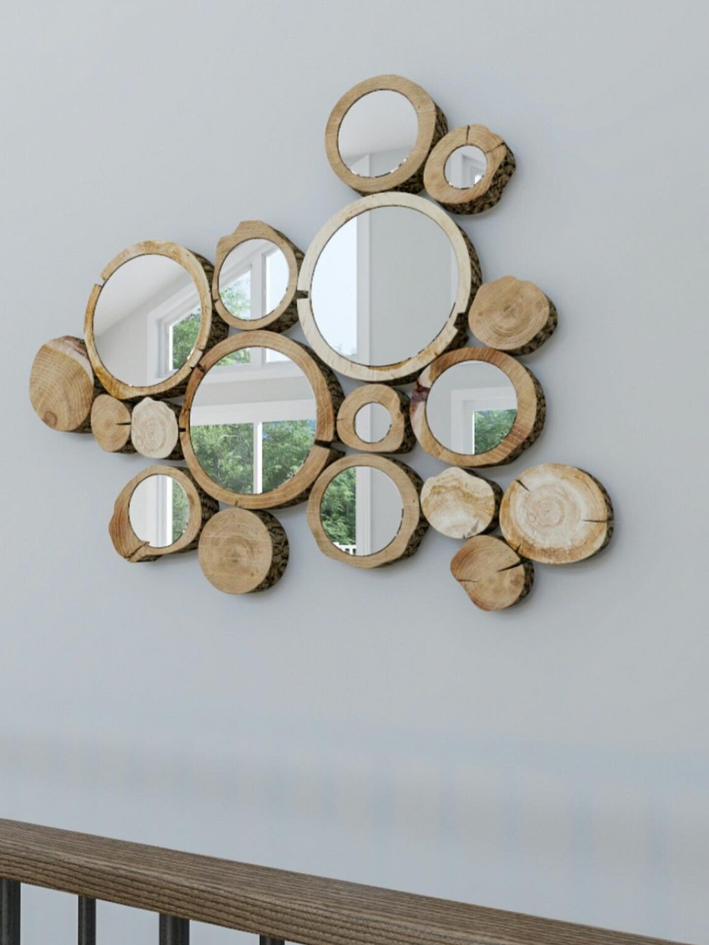 Collection of round wood slices and mirrors arranged in a cloud shape on a white wall