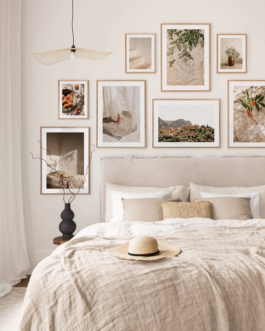 Gallery wall of beige and terracotta travel prints above linen bed
