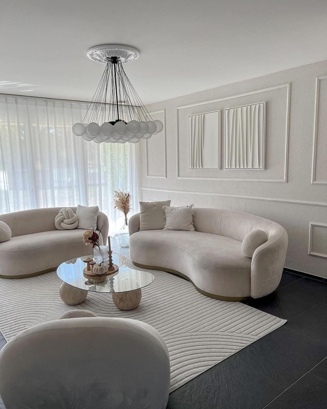 Minimalist white living room featuring rough textured walls, classic molding, and 3D wave relief art.