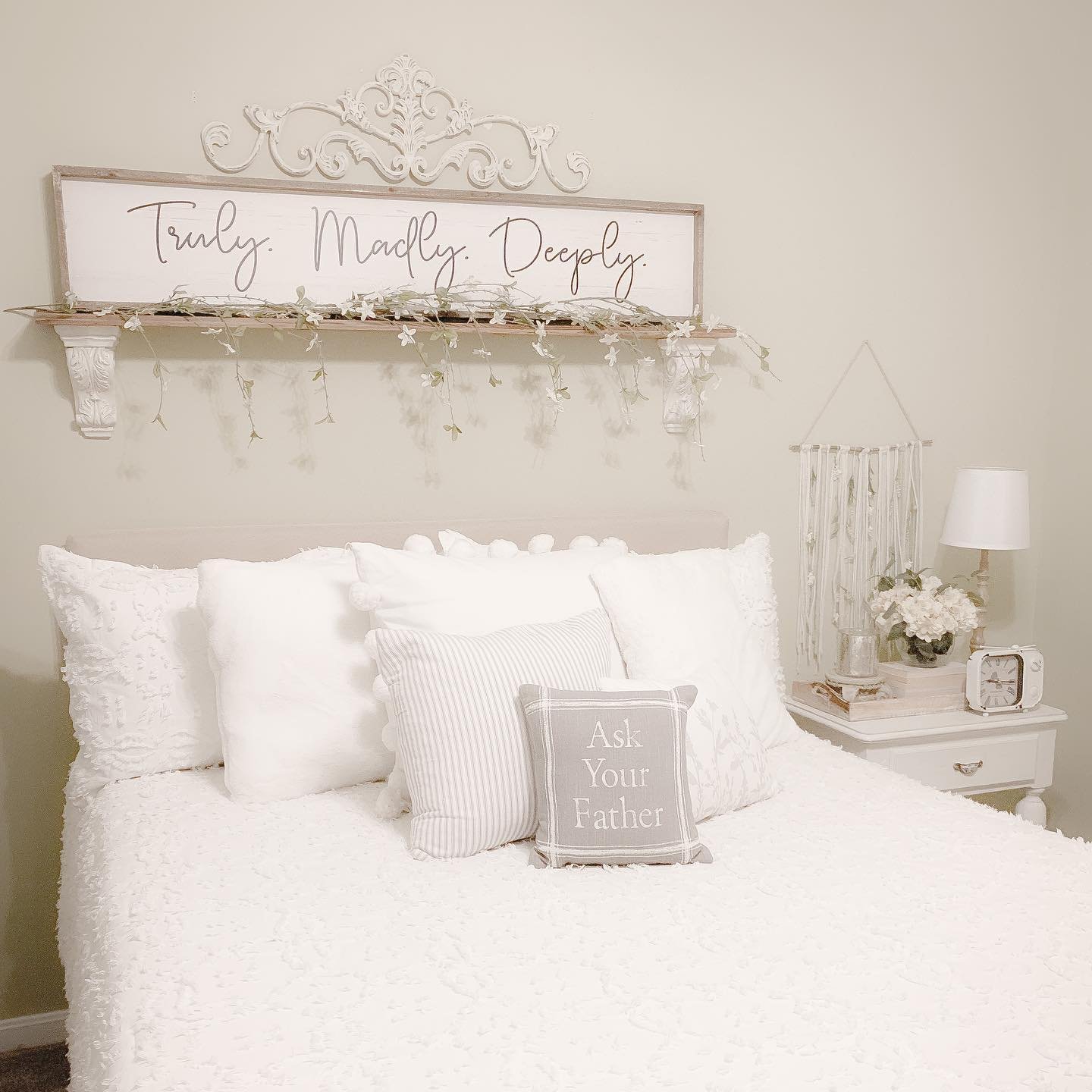 Truly Madly Deeply sign on shelf with greenery above white bed