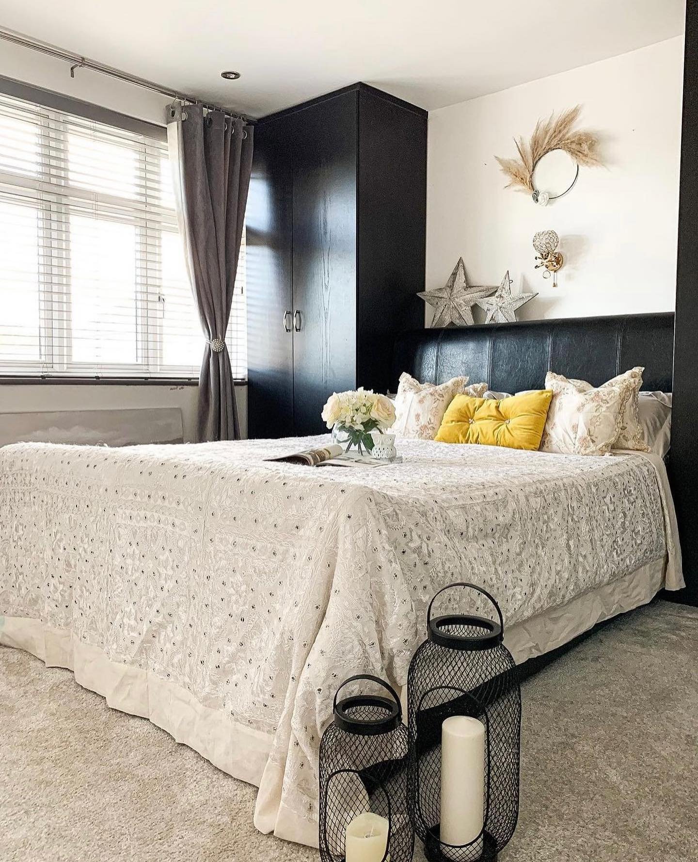 Silver stars and wreath wall decor between black fitted wardrobes