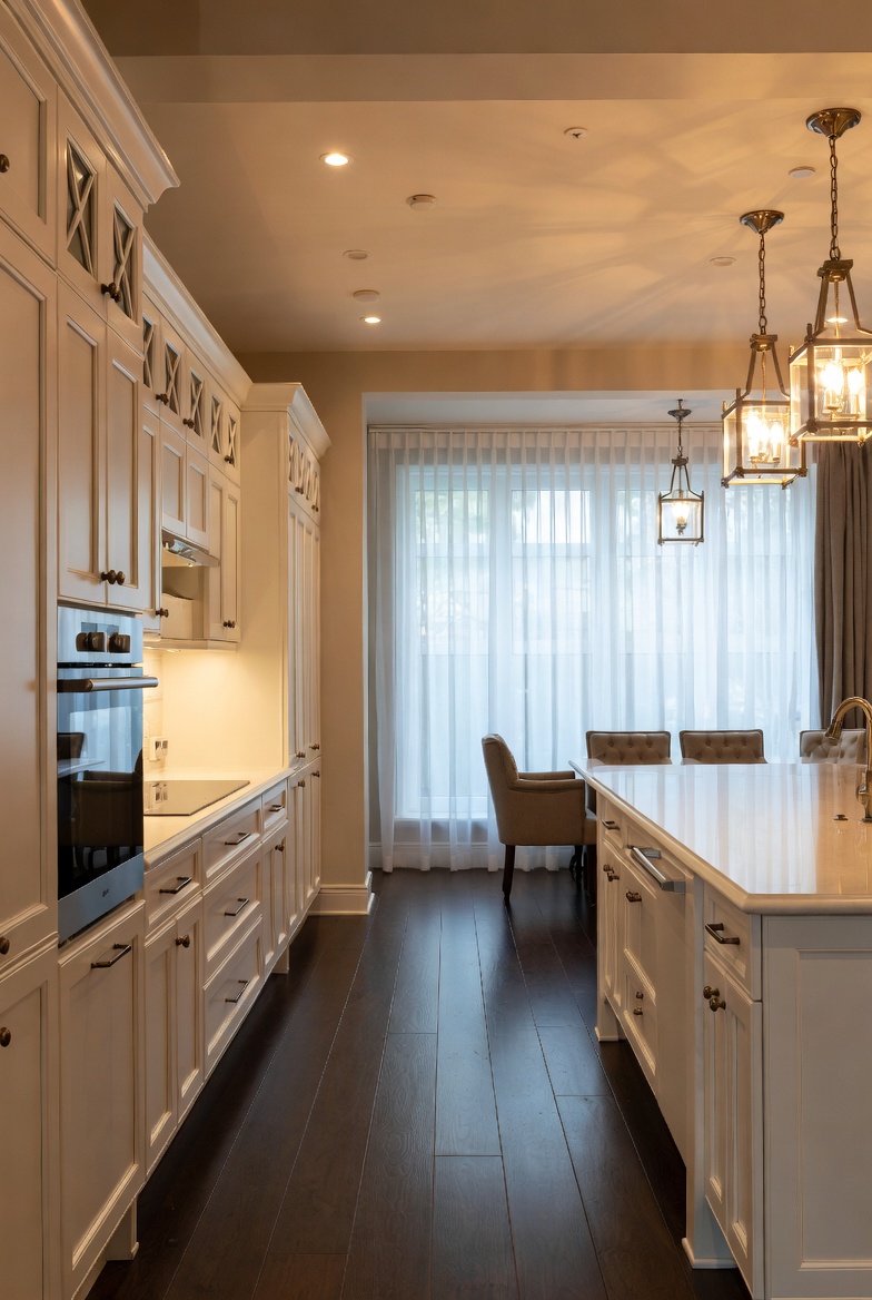 Traditional white kitchen featuring brass lantern pendant lights over a large island.