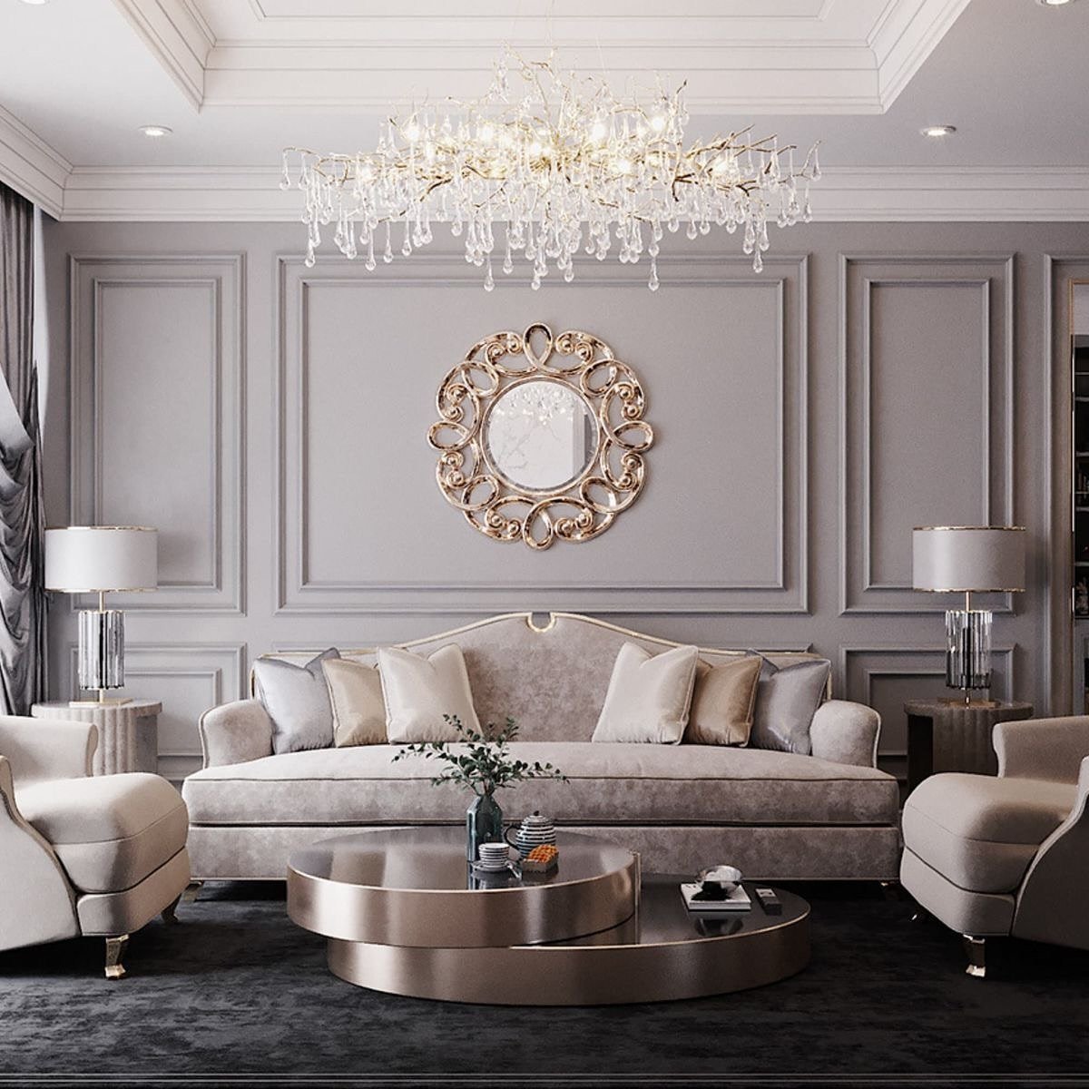 Grey neoclassical living room wall featuring picture frame molding and an ornate gold circular mirror.