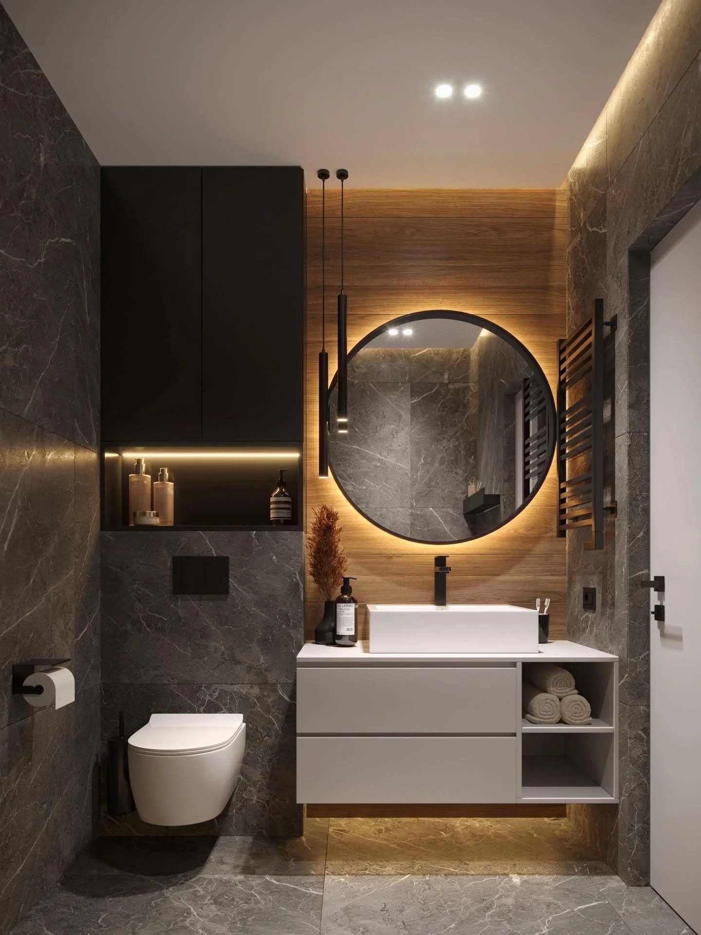 Modern bathroom with horizontal wood accent wall featuring backlit round mirror and hanging black pendant lights.