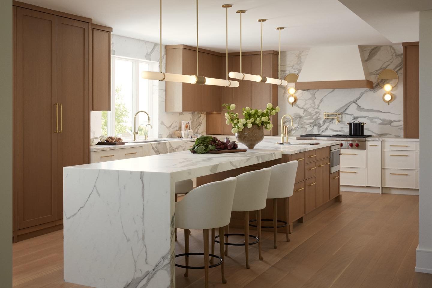 Two horizontal tube lights with brass accents hanging over a marble waterfall island.