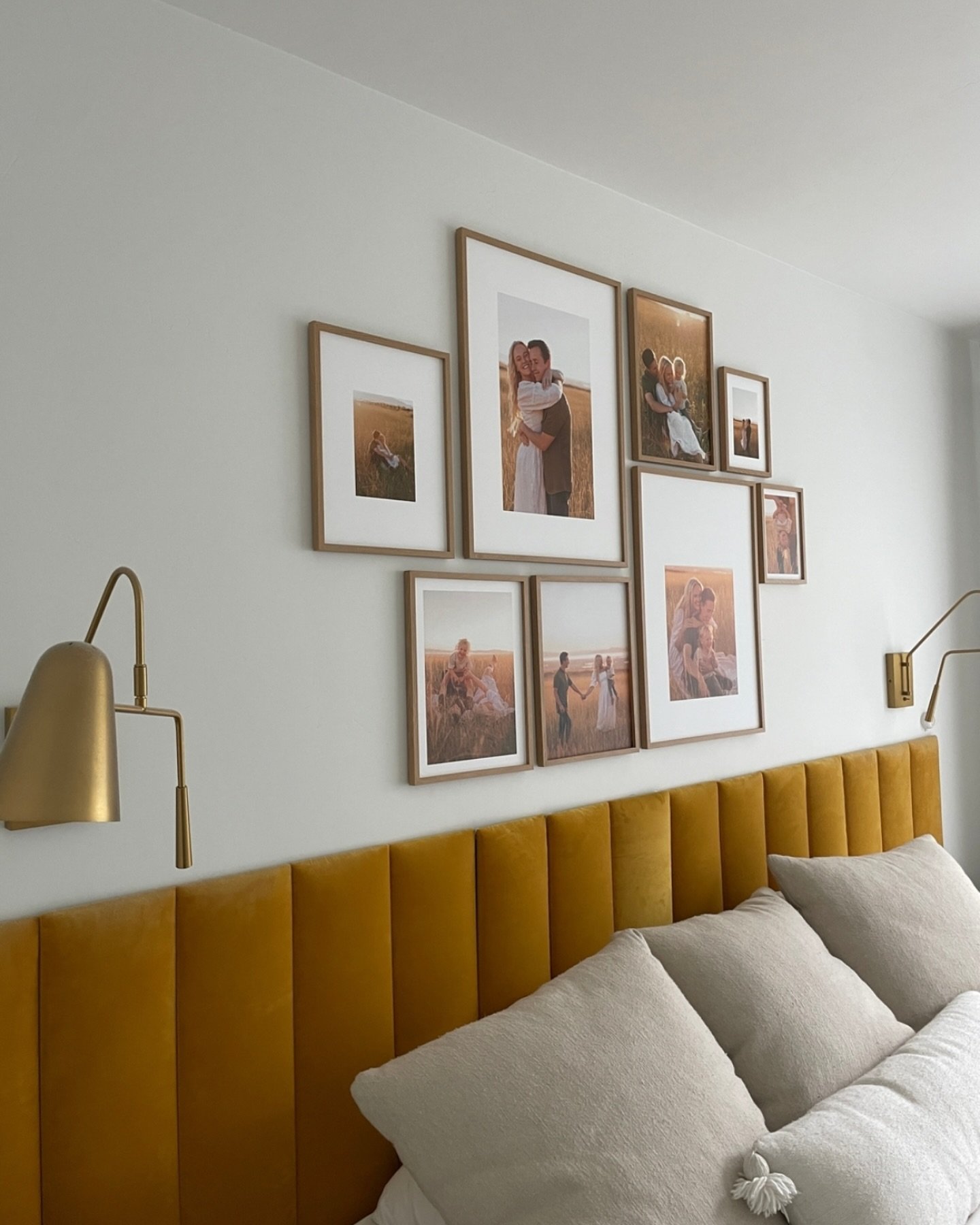 Framed family photos arranged above yellow velvet headboard