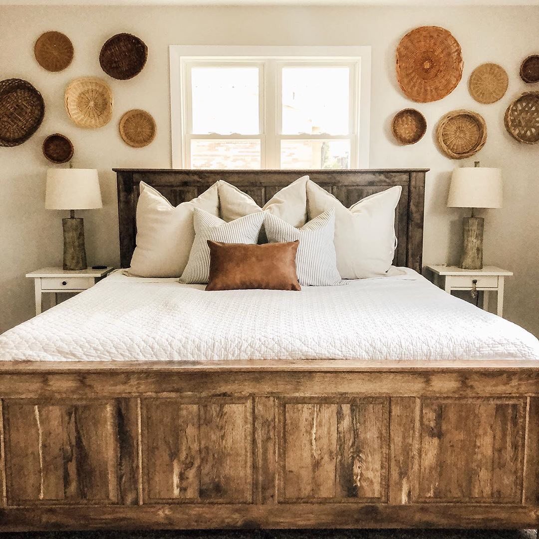 Collection of round woven baskets hanging on white wall surrounding bedroom window